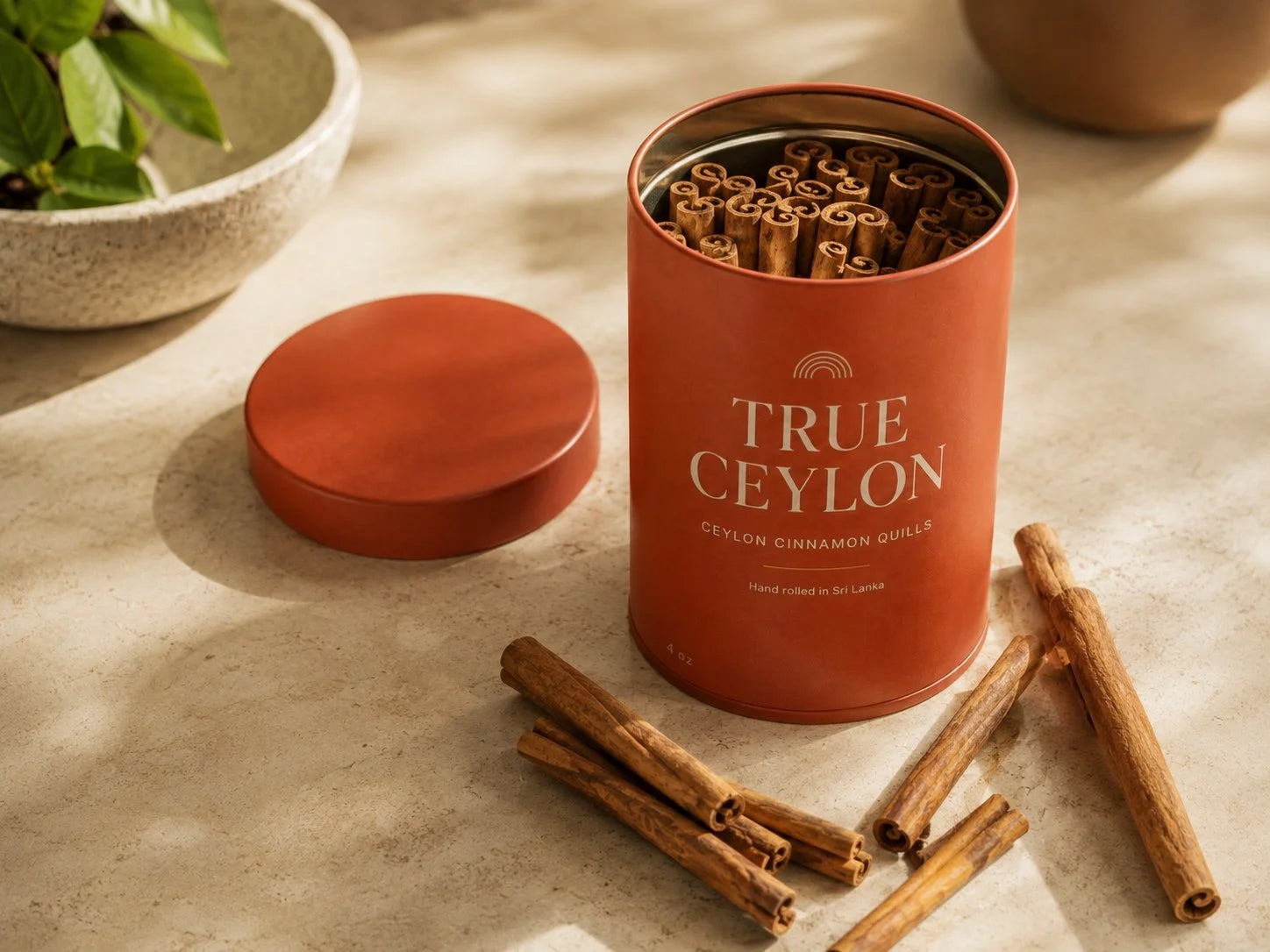 An open True Ceylon tin filled with whole Ceylon cinnamon quills, lid resting alongside